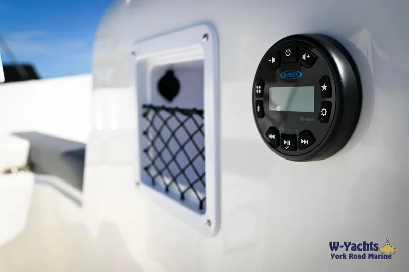 Slide: The Image of Close-up of 2023 Bayliner E18 boat control panel and storage compartment. - 17