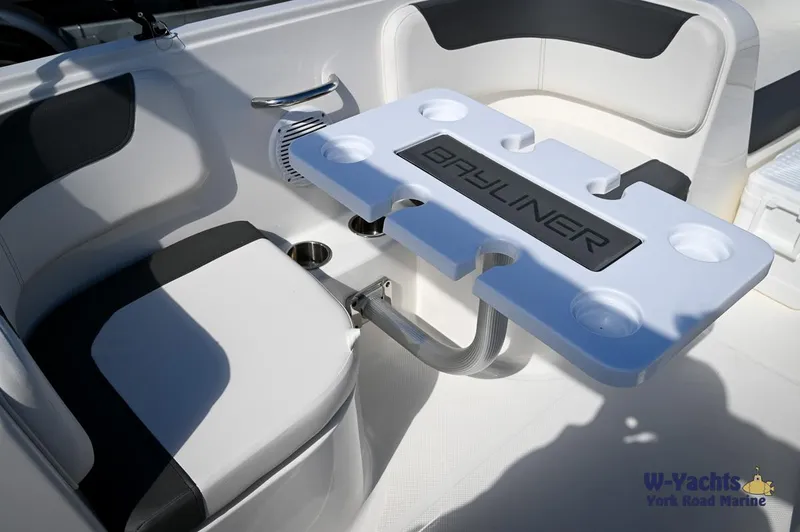 Slide: The Image of 2023 Bayliner E18 boat interior with seating and table. - 18