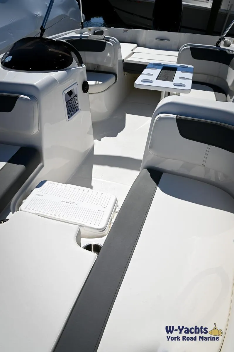 Slide: The Image of 2023 Bayliner E18 boat interior with seating and console. - 8