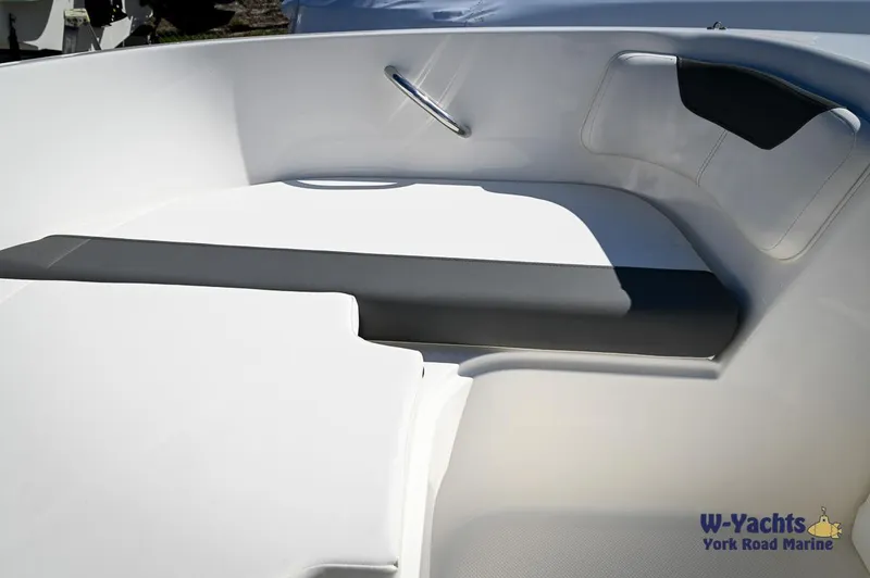 Slide: The Image of 2023 Bayliner E18 boat interior seating area with white and gray upholstery. - 9