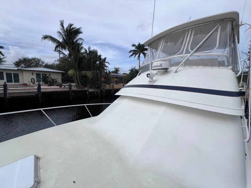 Slide: The Image of 1988 Bertram 43 Convertible yacht docked near waterfront homes. - 12