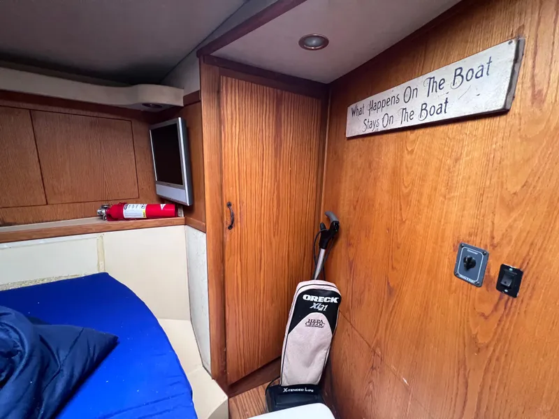 Slide: The Image of 1988 Bertram 43 Convertible cabin interior with wooden cabinets and a sign. - 43