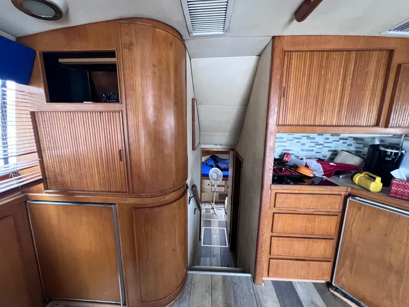 Slide: The Image of Interior of 1988 Bertram 43 Convertible yacht with wooden cabinetry and modern appliances. - 48