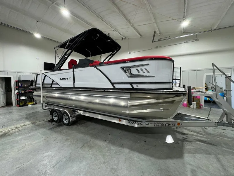 Slide: The Image of 2024 Crest Caribbean RS 230 SLRC pontoon boat displayed indoors. - 16