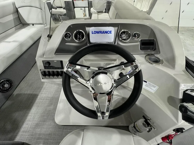 Slide: The Image of 2024 Crest Classic LX 220 boat dashboard with steering wheel and Lowrance display. - 14