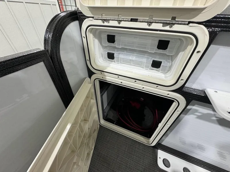 Slide: The Image of 2024 Crest Classic LX 220 storage compartments with open lids. - 20