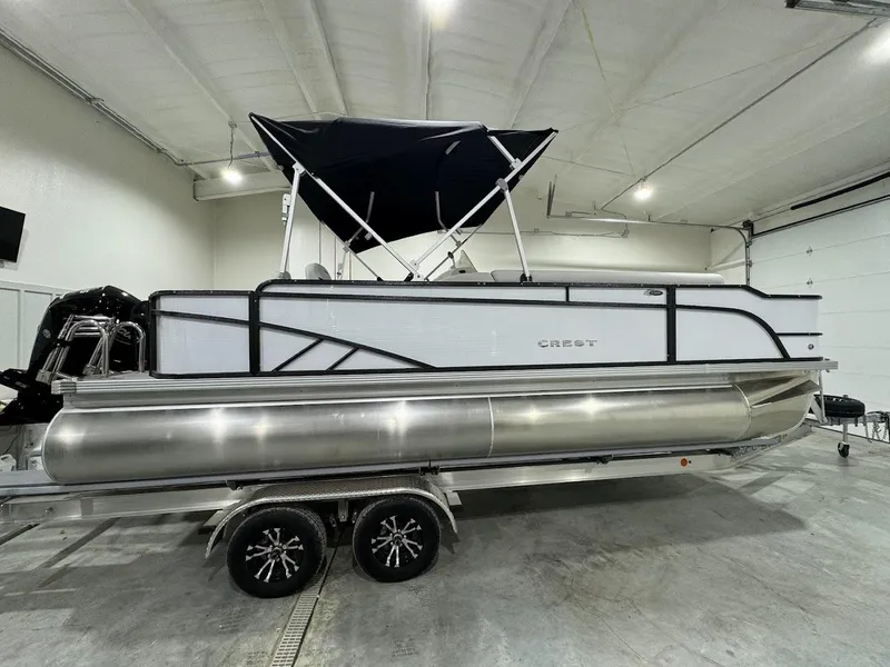Slide: The Image of 2024 Crest Classic LX 220 pontoon boat in indoor storage. - 3