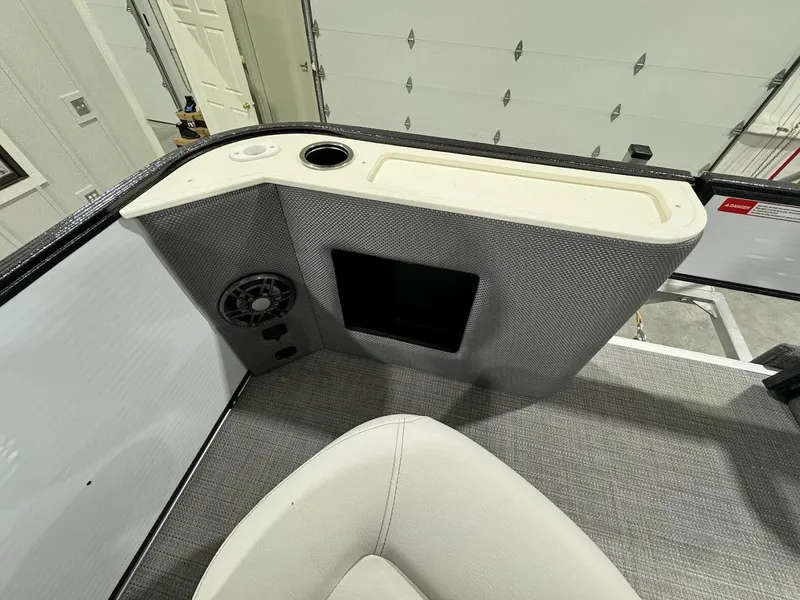 Slide: The Image of Interior of 2024 Crest Classic LX 220 boat, featuring a speaker and storage compartment. - 8