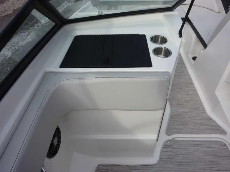 Slide: The Image of 2023 Sea Ray SPX 210 boat interior with cup holders and storage compartment. - 18