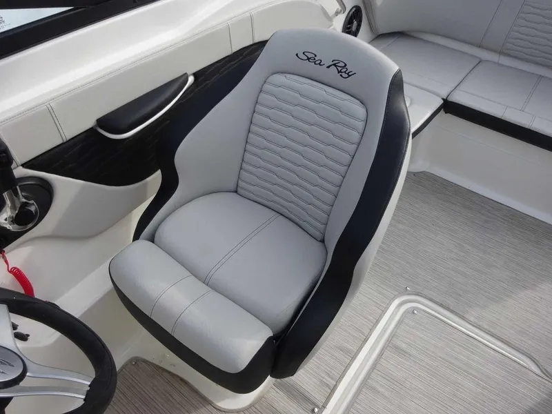 Slide: The Image of 2023 Sea Ray SPX 210 boat interior with grey captain's chair and seating area. - 8