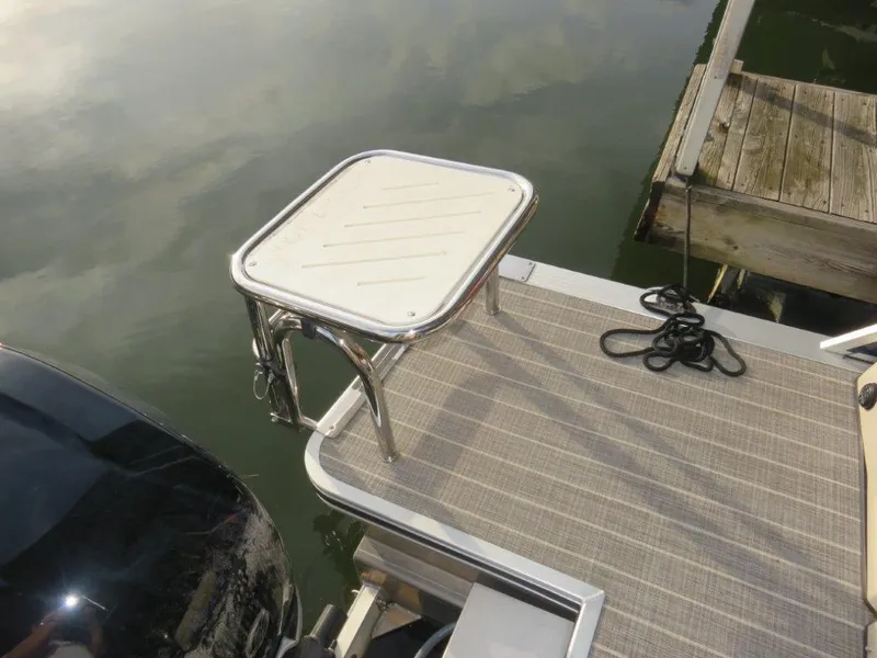 Slide: The Image of 2022 Harris Grand Mariner 250 boat deck with a mounted table and dock ropes. - 3