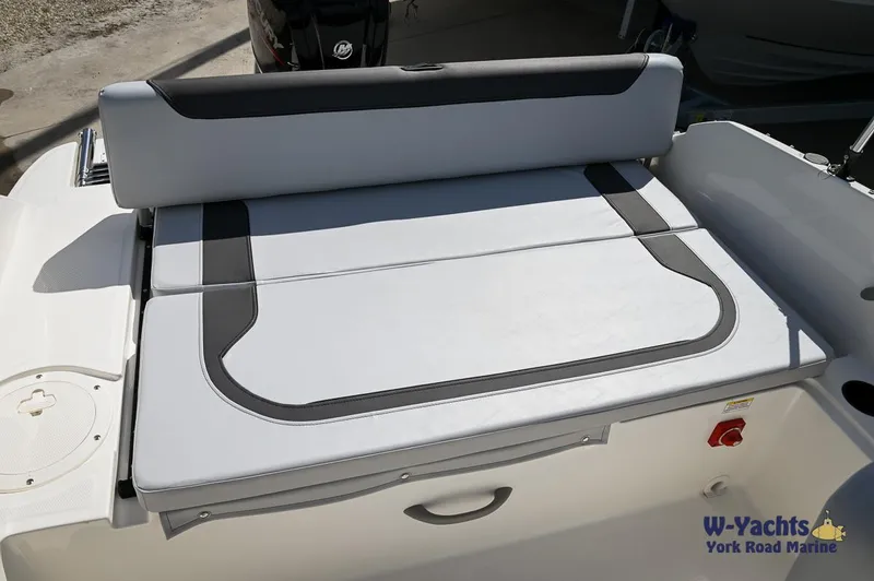 Slide: The Image of 2024 Bayliner M19 boat rear seating area with cushion and storage compartment. - 13