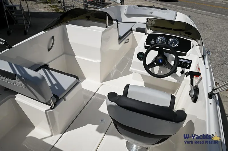 Slide: The Image of 2024 Bayliner M19 boat interior with steering console and seating. - 8