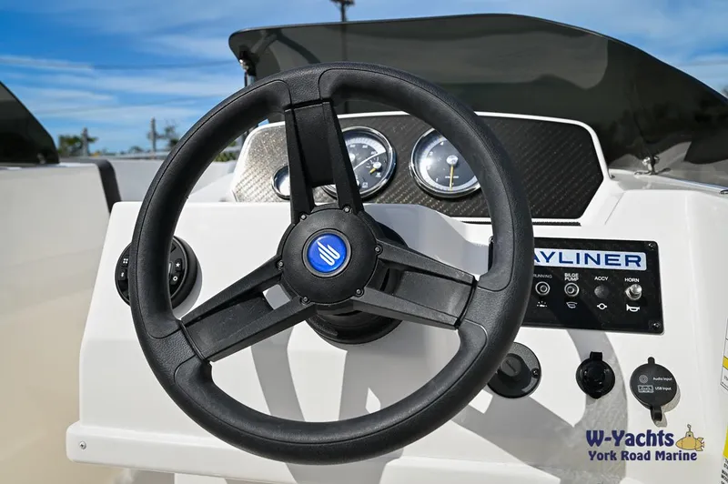 Slide: The Image of 2024 Bayliner M19 boat steering wheel and dashboard controls. - 9