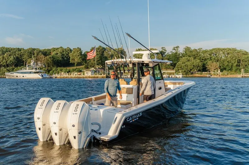 Slide: The Image of 2024 Caymas 341 CC boat with triple engines on a scenic lake. - 10