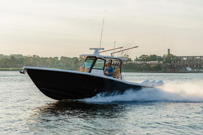 Slide: The Image of 2024 Caymas 341 CC boat cruising on a river with fishing rods. - 11