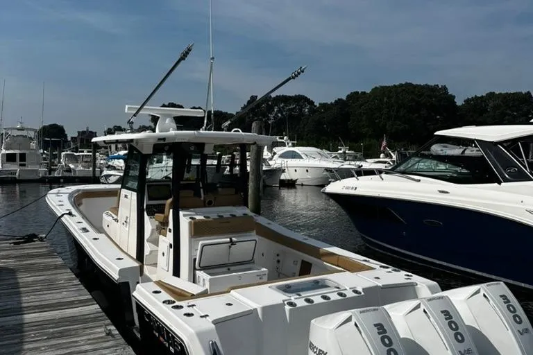 Slide: The Image of 2024 Caymas 341 CC boat docked at marina, surrounded by other boats. - 12