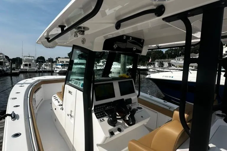Slide: The Image of 2024 Caymas 341 CC boat interior with modern controls, docked at a marina. - 13