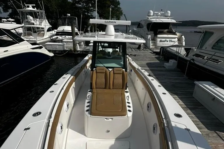 Slide: The Image of 2024 Caymas 341 CC boat docked, featuring sleek design and advanced Garmin navigation system. - 14
