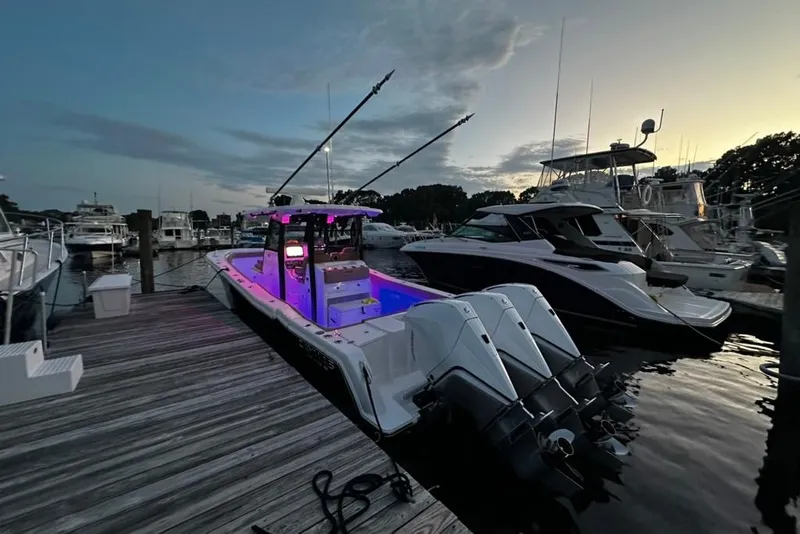 Slide: The Image of 2024 Caymas 341 CC boat docked at marina during sunset with vibrant interior lighting. - 15