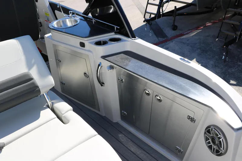 Slide: The Image of 2024 Sylvan G5 CLZ DC boat interior with sink, storage cabinets, and seating. - 33
