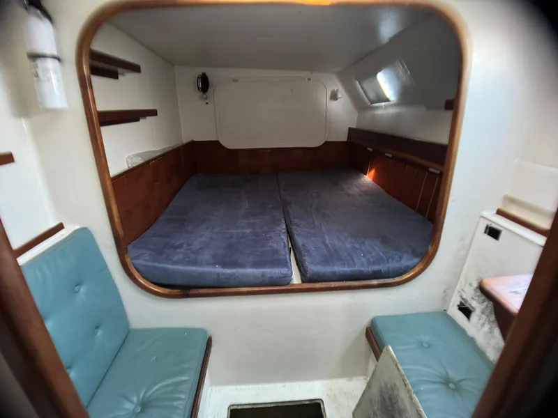 Slide: The Image of Cozy cabin interior of 1998 Catamaran Vision 51 with blue cushions and wooden accents. - 10