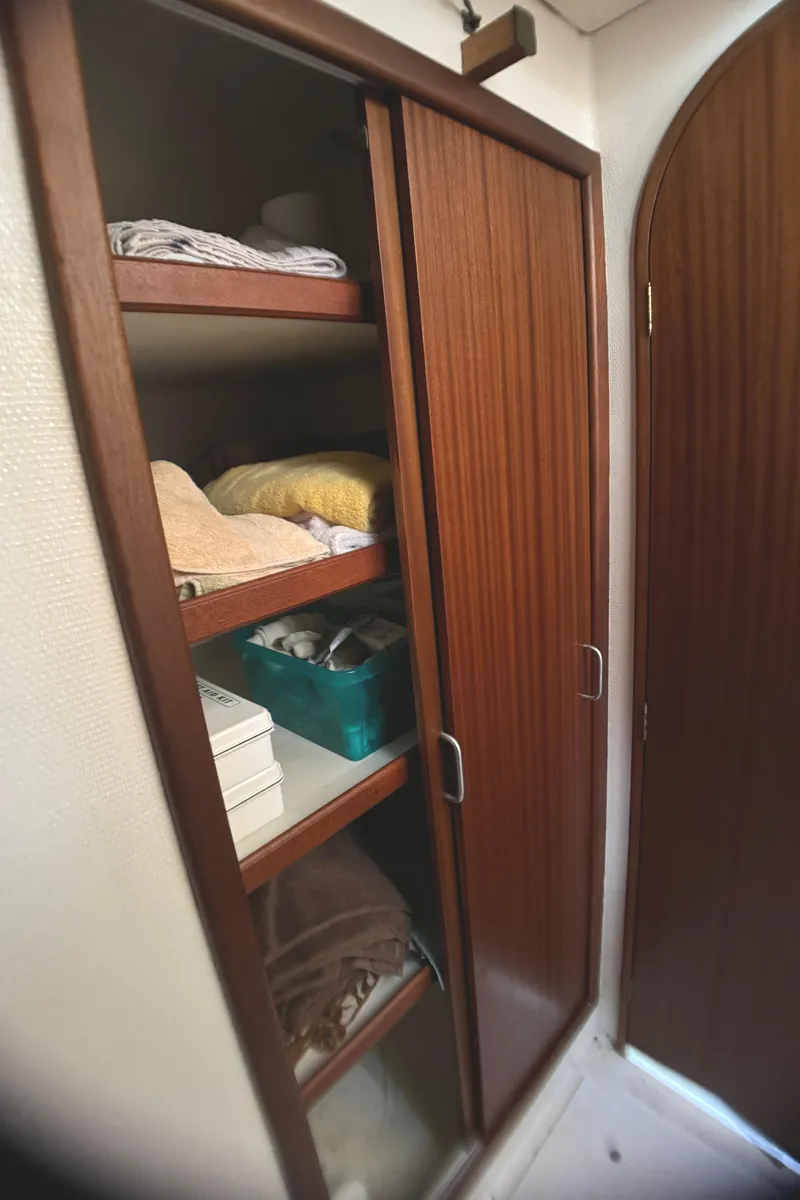 Slide: The Image of Wooden cabinet with sliding doors and shelves on a 1998 Catamaran Vision 51. - 16