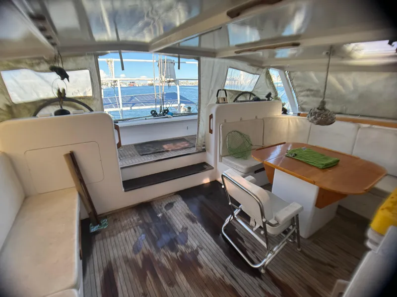 Slide: The Image of Interior of 1998 Catamaran Vision 51 with seating and dining area, overlooking the ocean. - 17