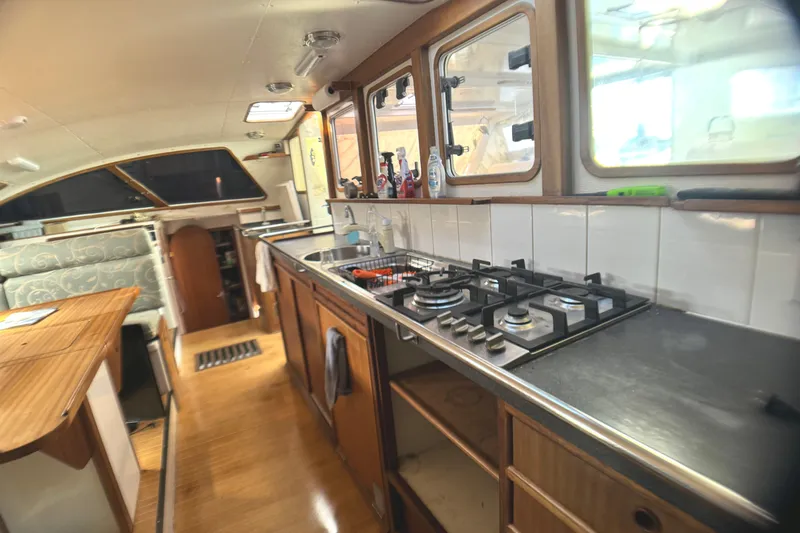 Slide: The Image of Interior of 1998 Catamaran Vision 51, featuring a modern kitchen with stove and sink. - 2