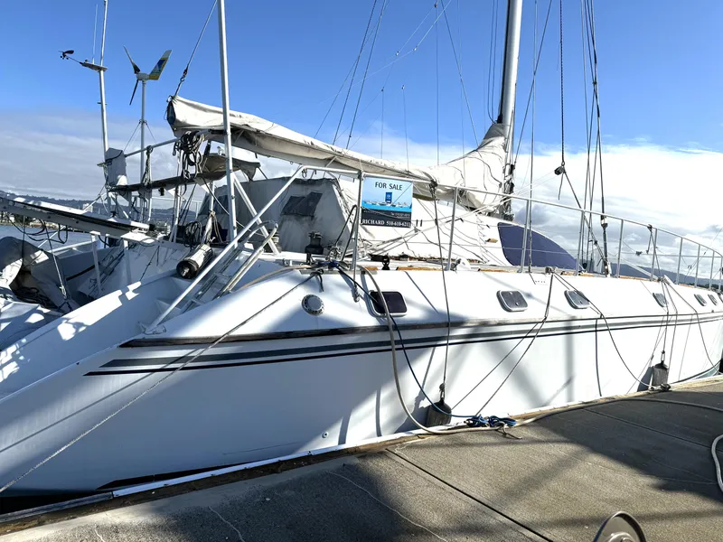 Slide: The Image of 1998 Catamaran Vision 51 sailboat docked, for sale sign visible, clear sky background. - 27
