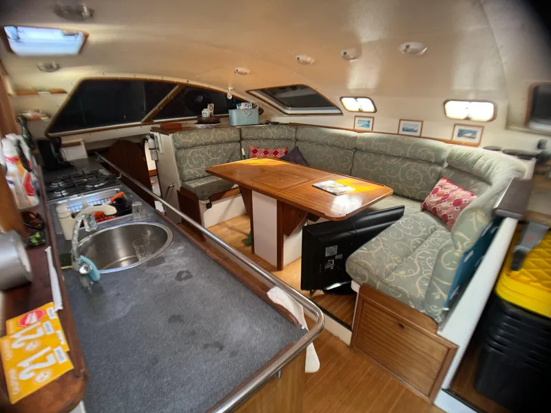Slide: The Image of Interior of 1998 Catamaran Vision 51 with cozy seating and kitchen area. - 4