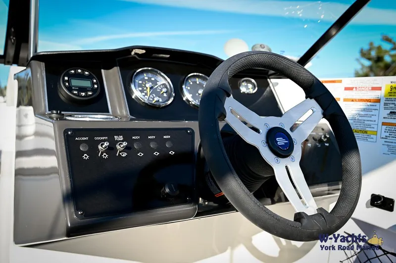 Slide: The Image of 2024 Bayliner VR5 boat dashboard with steering wheel and control panel. - 11