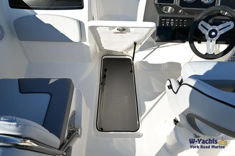 Slide: The Image of 2024 Bayliner VR5 boat interior with open storage compartment and steering wheel. - 13