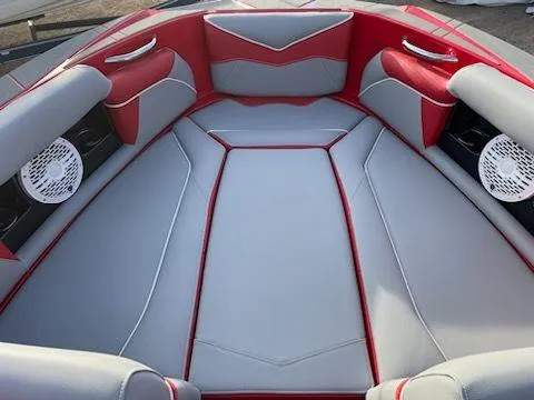 Slide: The Image of 2024 Supreme S240 boat interior with red and gray seating and built-in speakers. - 10