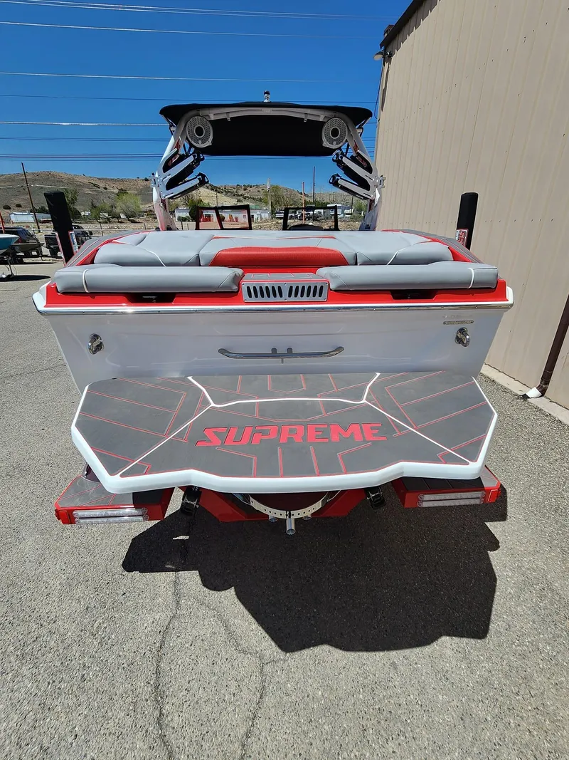 Slide: The Image of 2024 Supreme S240 boat rear view with red and white design. - 2