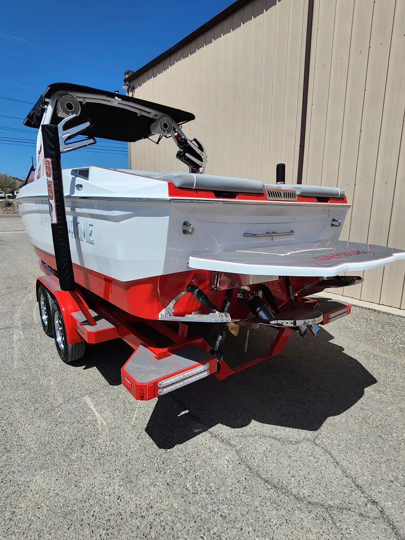 Slide: The Image of 2024 Supreme S240 boat on a red trailer, rear view. - 5