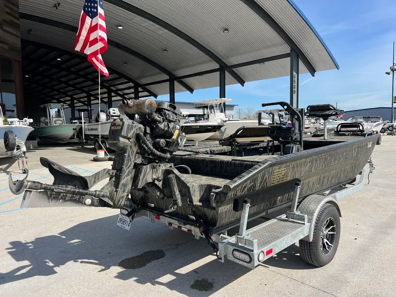 Slide: The Image of 2022 Prodigy 1751 boat on a trailer at a dealership with an American flag. - 2