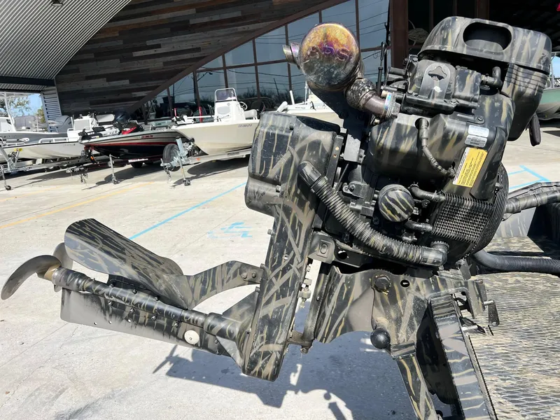 Slide: The Image of Prodigy 1751 boat motor, 2022 model, camo design, displayed outdoors near other boats. - 4