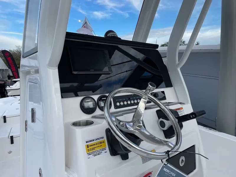 Slide: The Image of 2024 Sea Fox 231 Bay Fox boat console with steering wheel and navigation display. - 13