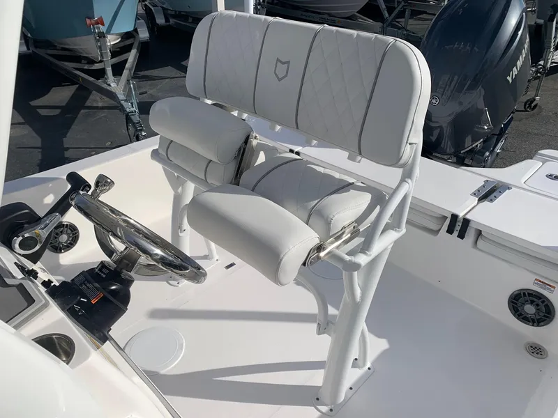 Slide: The Image of 2024 Sea Fox 231 Bay Fox boat helm with cushioned seating and steering wheel. - 15