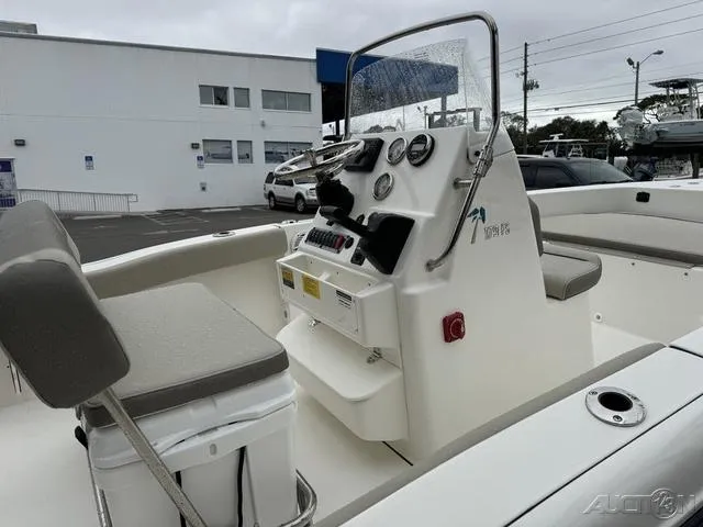 Slide: The Image of 2024 Key West 179 FS boat interior with seating and motor, displayed at a dealership. - 12