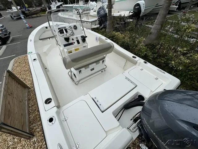 Slide: The Image of 2024 Key West 179 FS boat interior with steering console and seating, parked in a marina. - 22