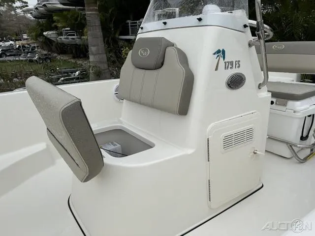 Slide: The Image of 2024 Key West 179 FS boat with console and seating, surrounded by tropical foliage. - 24