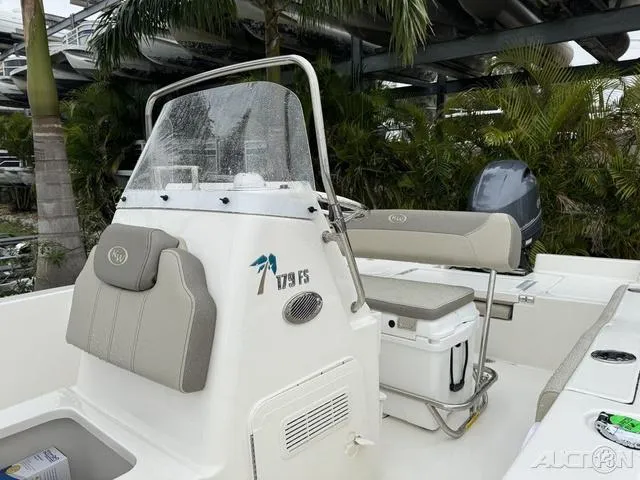 Slide: The Image of 2024 Key West 179 FS boat with seating, console, and palm trees in the background. - 25