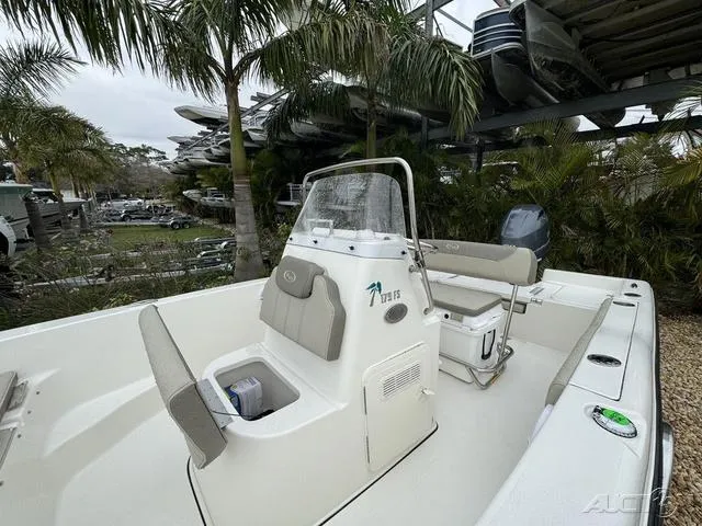 Slide: The Image of 2024 Key West 179 FS boat with seating, console, and palm trees in the background. - 26