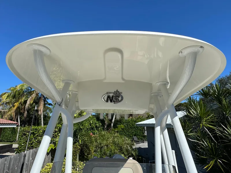 Slide: The Image of 2017 NauticStar 20 XS Offshore boat T-top under clear blue sky. - 16