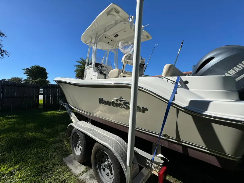 Slide: The Image of 2017 NauticStar 20 XS Offshore boat on a trailer in a yard. - 3
