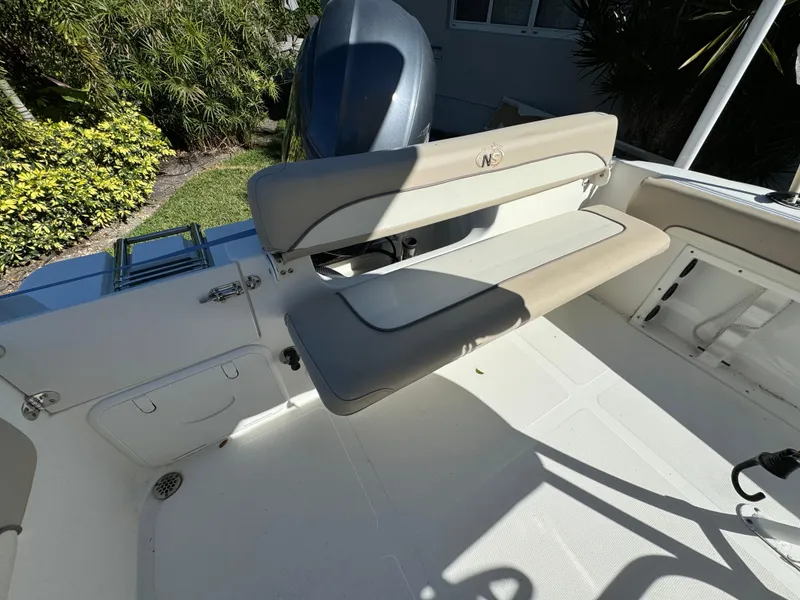 Slide: The Image of 2017 NauticStar 20 XS Offshore boat interior with cushioned seating and engine. - 9