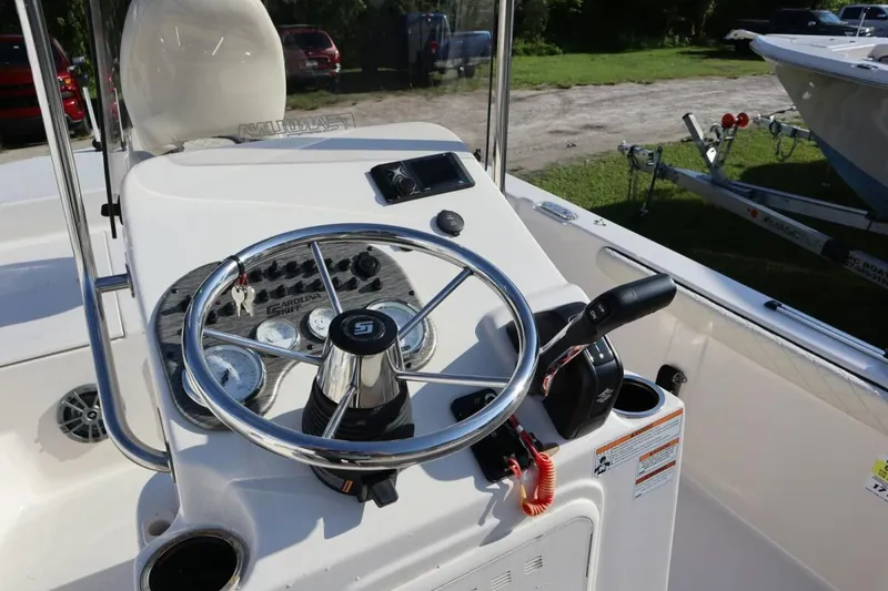 Slide: The Image of 2023 Carolina Skiff 17 LS boat console with steering wheel and controls. - 10