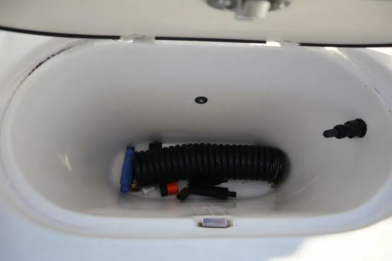 Slide: The Image of Storage compartment of 2023 Carolina Skiff 17 LS boat with coiled hose and accessories. - 14